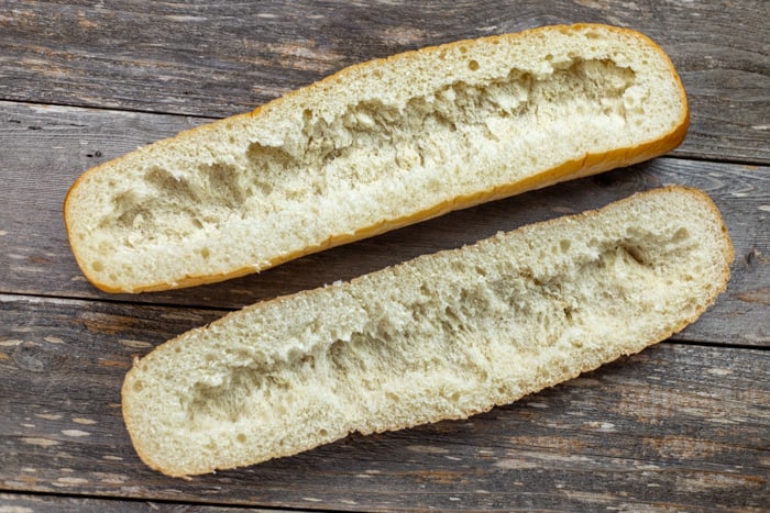 french bread that has been sliced in half and some contents removed to make garbage bread