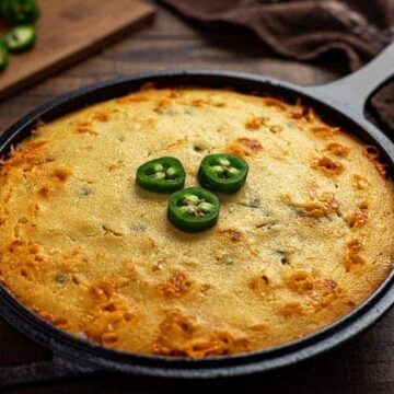 baked cornbread in cast iron skillet with jalapeno slices garnish on top