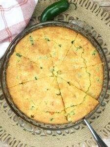 baked cornbread in a glass pie plate with jalapeno on the side
