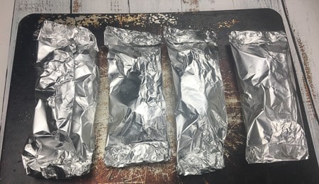4 foil packets on metal baking sheet