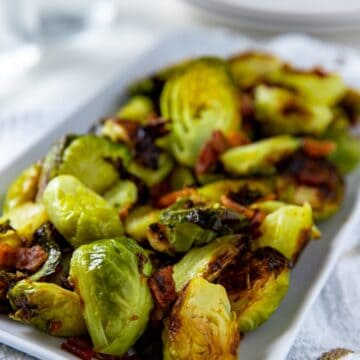 cooked brussels sprouts and bacon in white rectangular dish