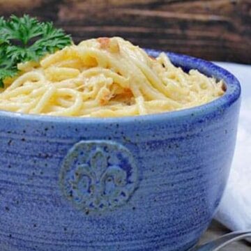 rotel chicken spaghetti in blue bowl with white napkin and fork