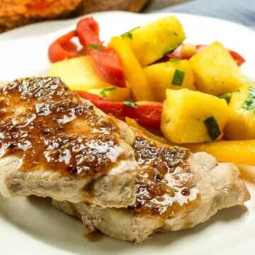 sweet & sour pork chops on white plate with bell pepper slices and pineapple chunks