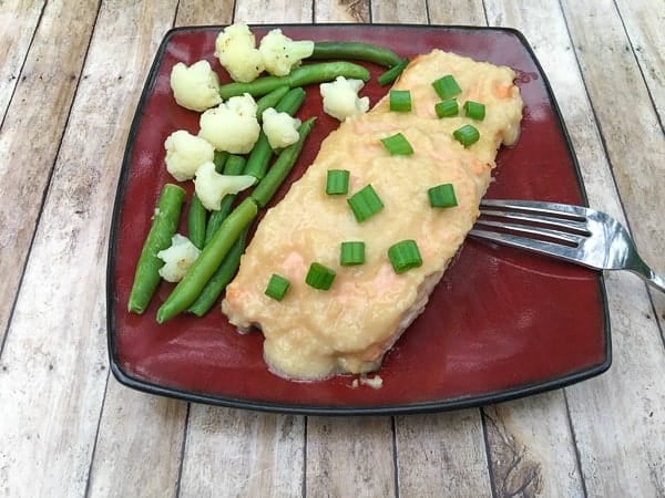 miso ginger salmon with green onions on red plate