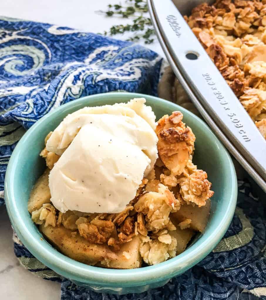 baked crisp in blue bowl with scoop of ice cream on topo