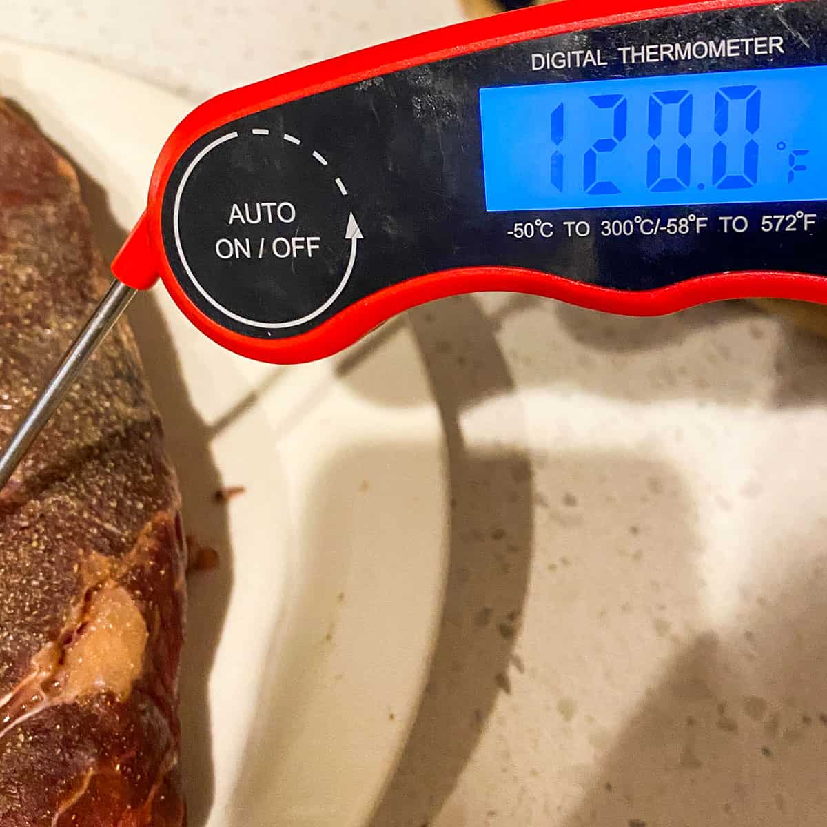 digital meat thermometer in steak showing a reading of 120F