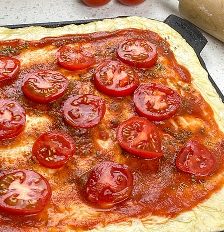 add sliced tomatoes to pizza