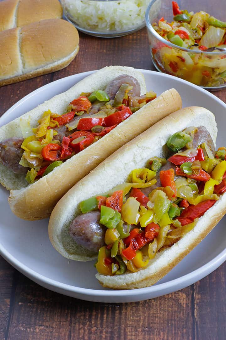 brats with sausage and peppers on white plate