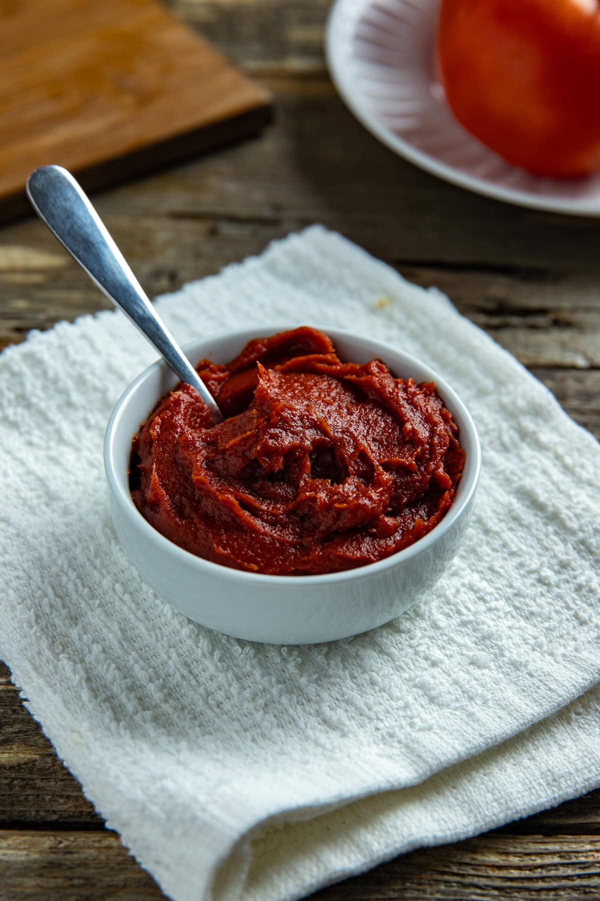 A small white bowl containing tomato paste.