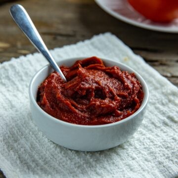 A small white bowl containing tomato paste.