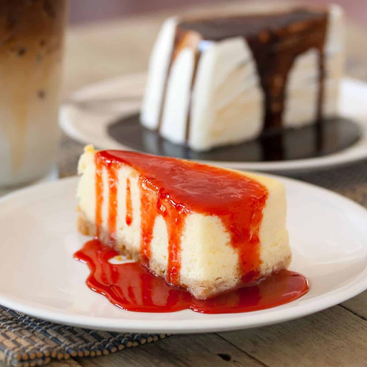 cheesecake slices topped with fruit sauce and chocolate sauce