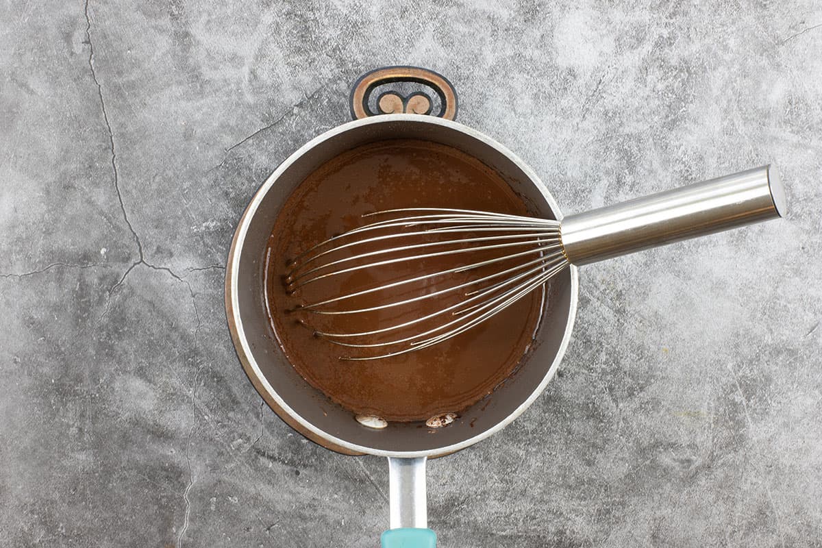 small sauce pan with cocoa, butter, and water. Whisk in pan.