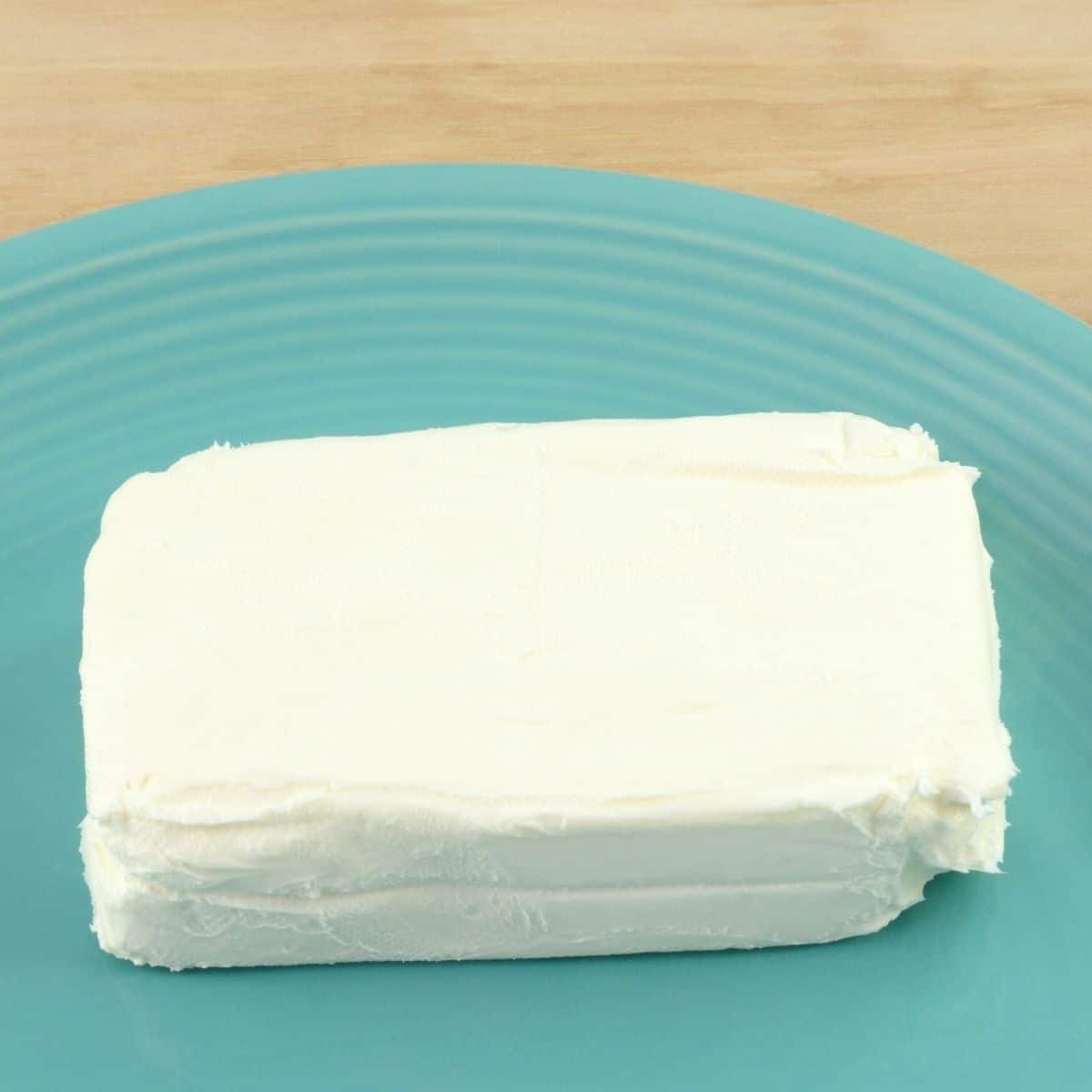 rectangular block of cream cheese on teal blue plate