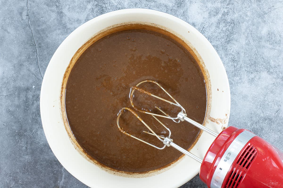 chocolate batter in mixing bowl with red electric mixer in bowl