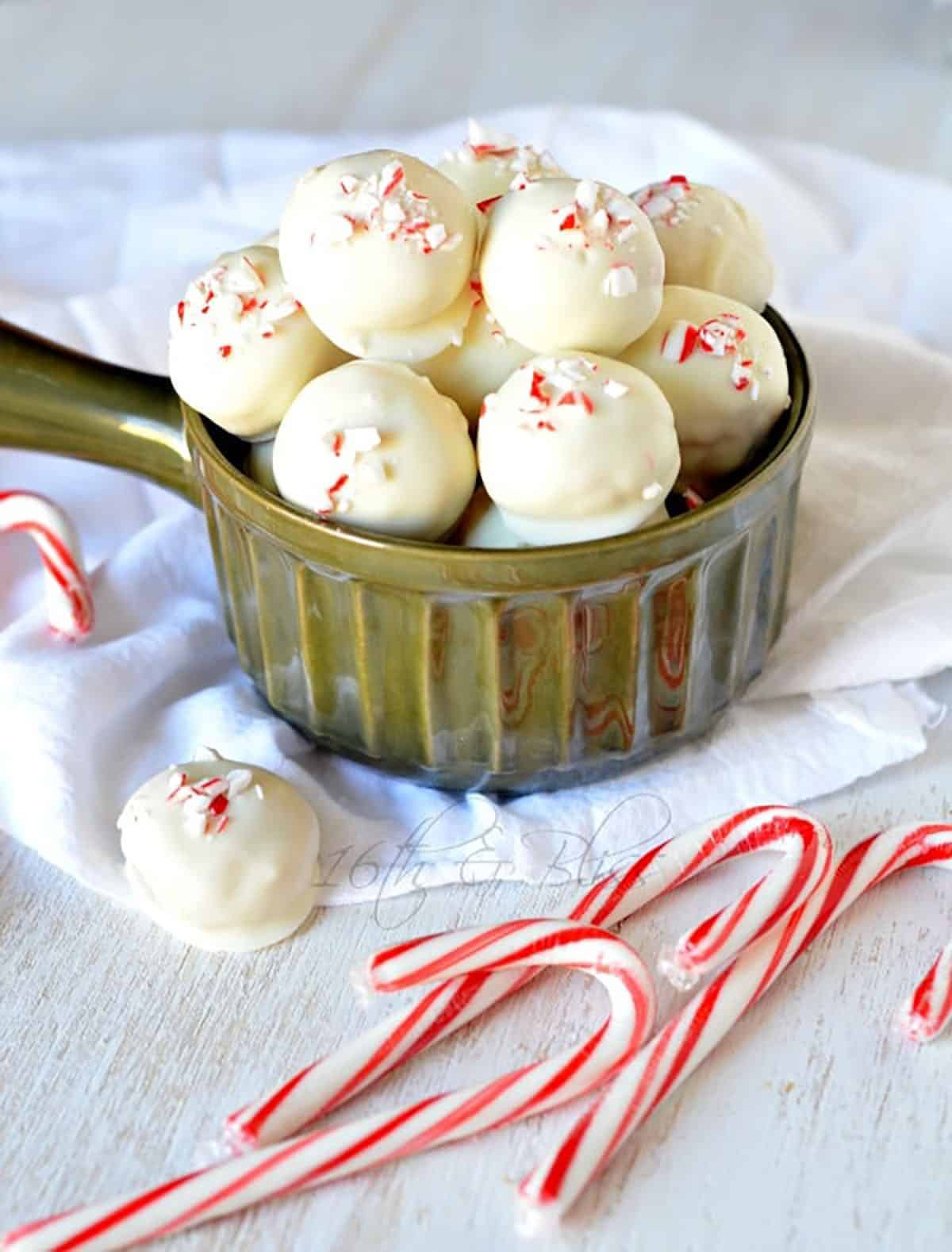 bowl full of white chocolate peppermint truffles with candy canes in foreground