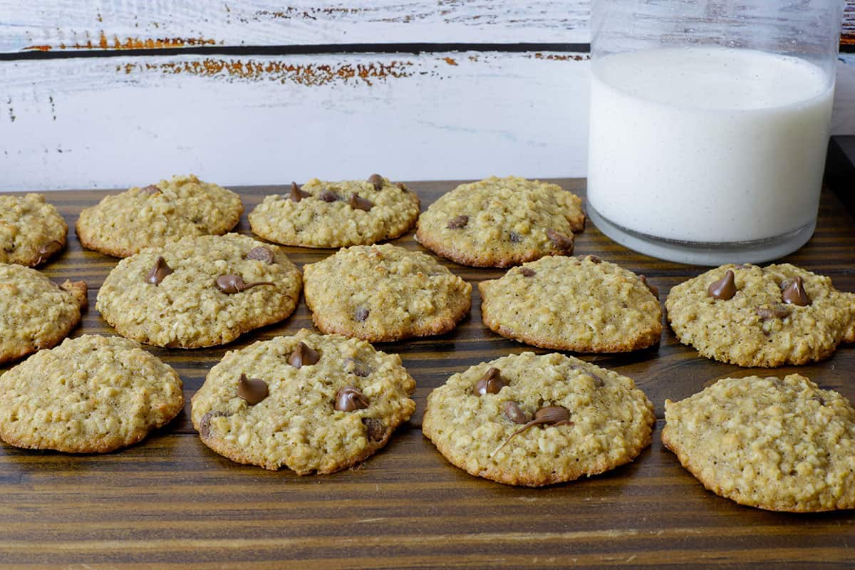 baked cookies on wooden board with glass of milk in background