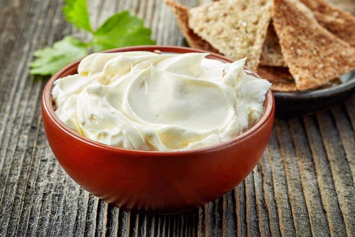 thawed and stirred cream cheese in a red bowl