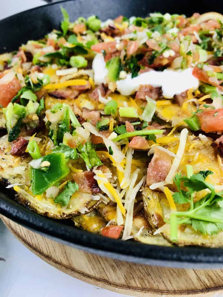 close up view of assembled nachos in skillet