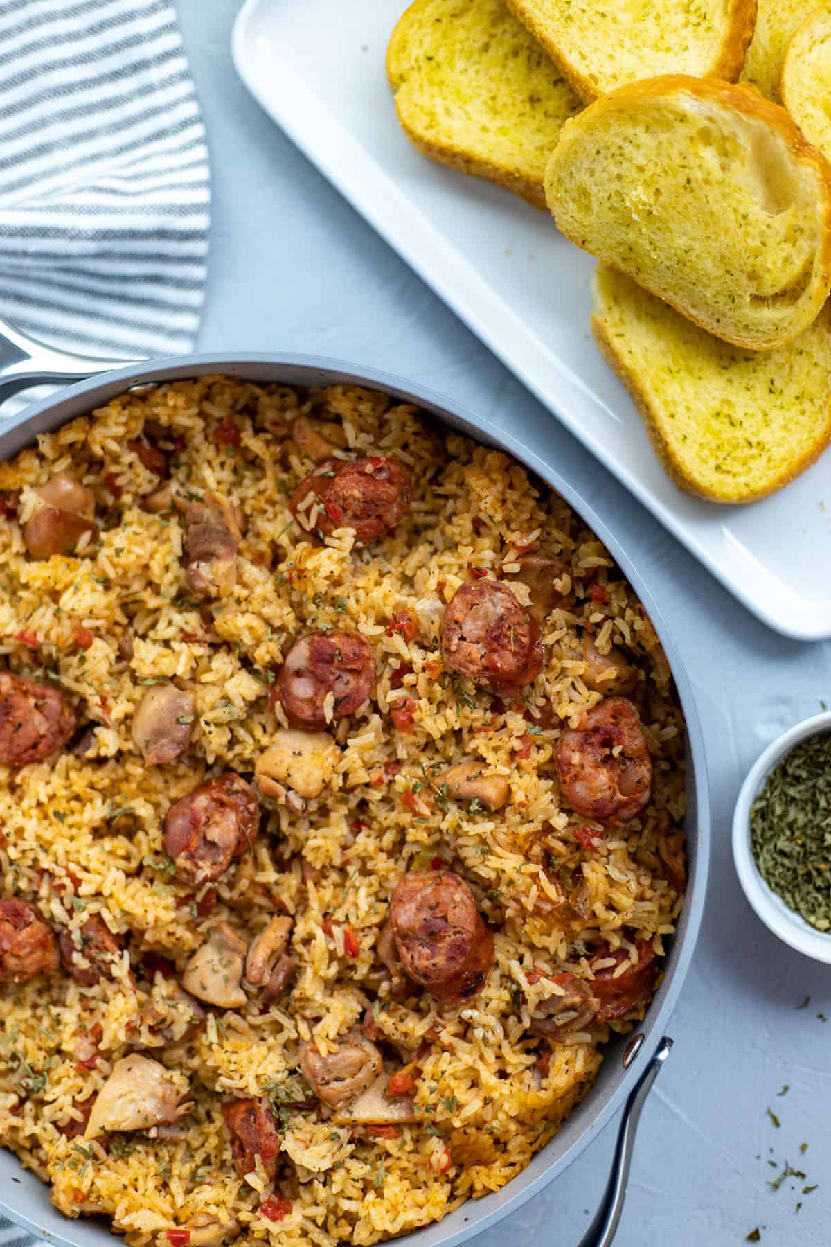 Cooked Chicken and Sausage Jambalaya in pan with toasted french bread on the side