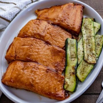 picture of grilled salmon with bbq sauce and zucchini on white plate