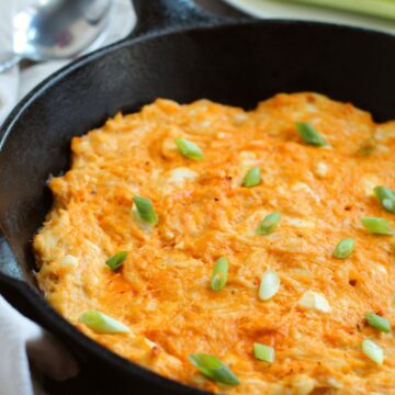 hot dip topped with fresh green onion slices in cast iron skillet