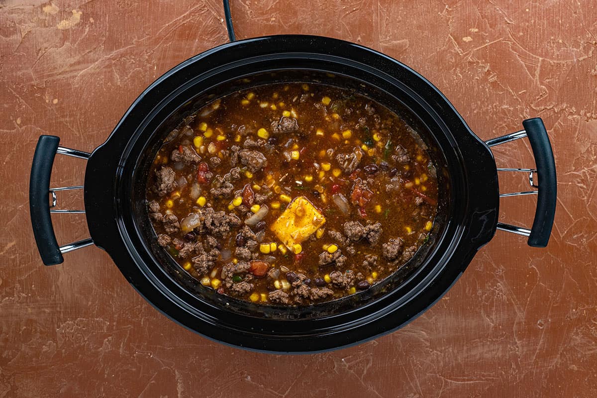 Ground beef, corn, beans and other ingredients in a crockpot.