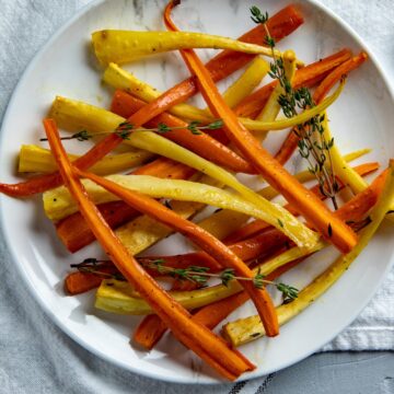 Overhead View of Roasted Carrots and Parsnips on white serving plate.