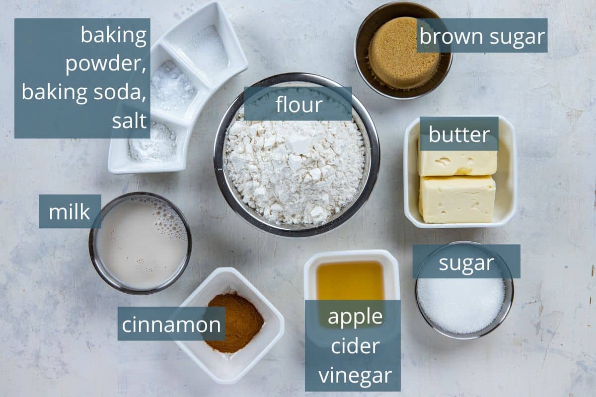 Cinnamon roll ingredients measured out in individual containers on countertop.