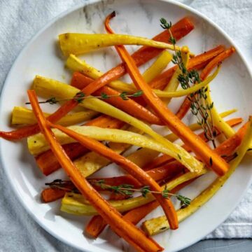 Overhead View of Roasted Carrots and Parsnips on white serving plate.