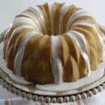 Baked cake on wooden cake pedestal.