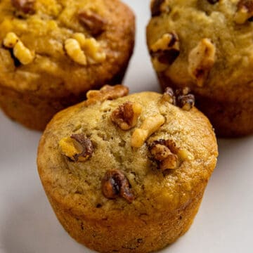 three baked muffins on white plate.