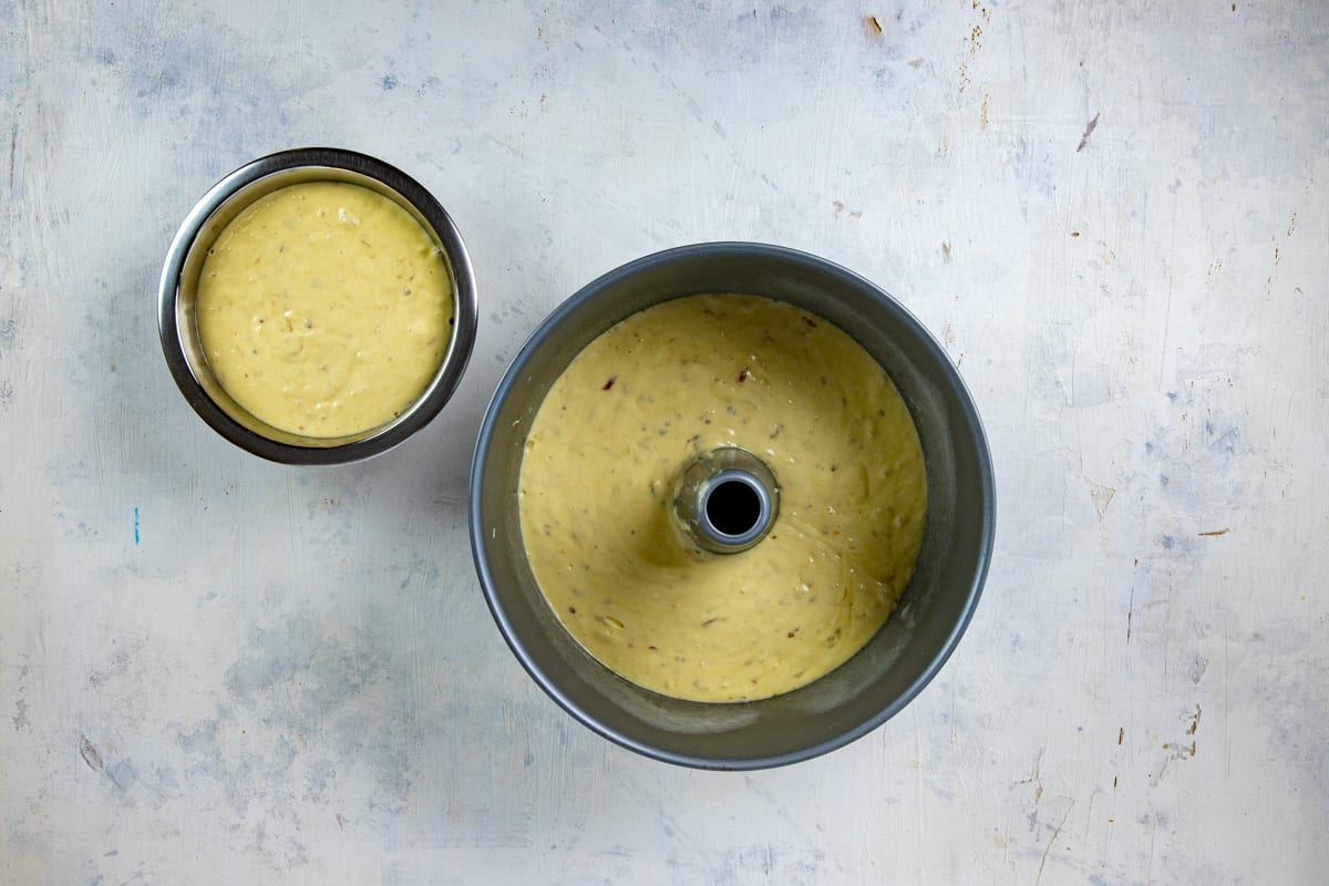 Cake batter in tube pan with 2 cups of batter removed and saved in a small bowl.