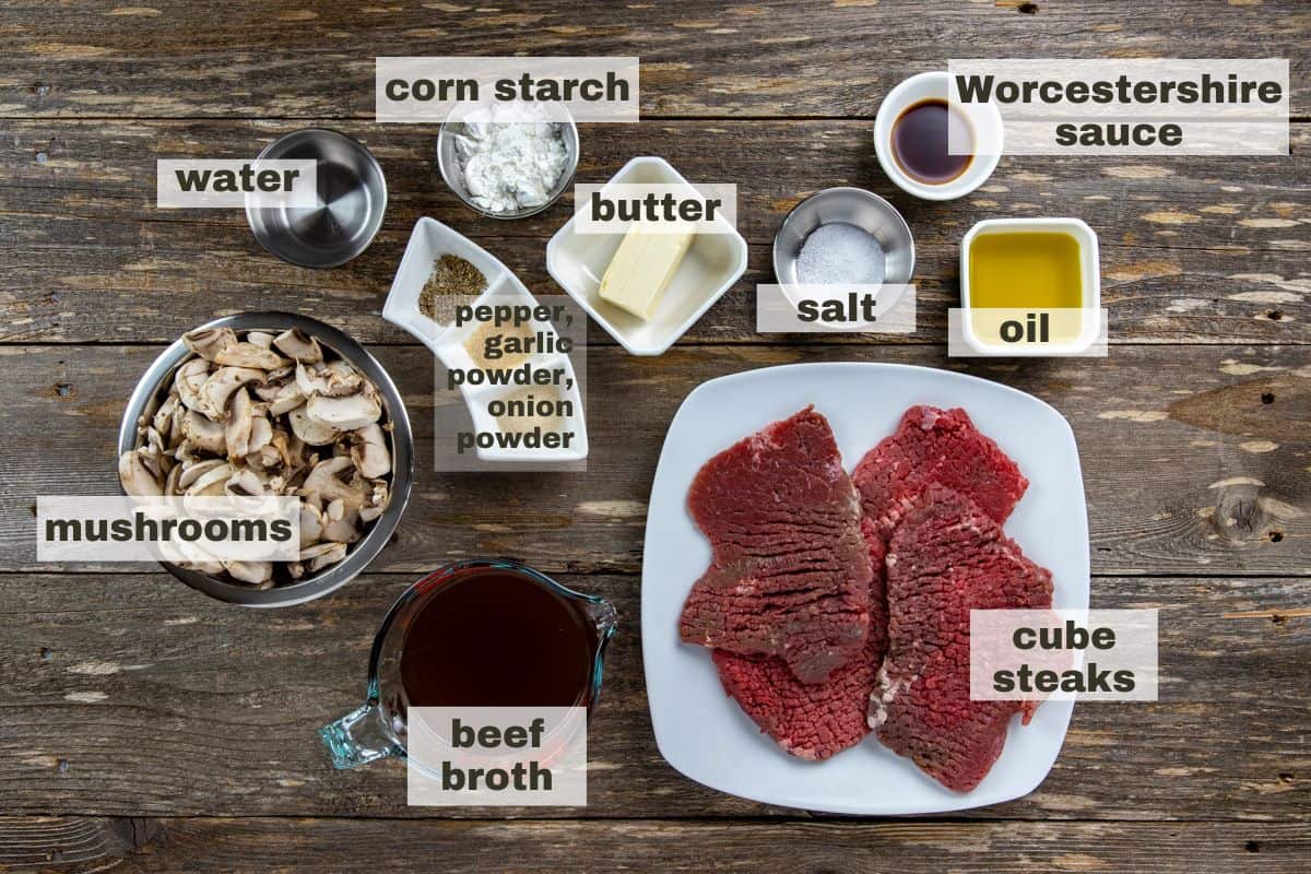 Recipe ingredients measured out in individual bowls.  Cube steaks, beef broth, sliced mushrooms, butter, oil, cornstarch, and seasonings.