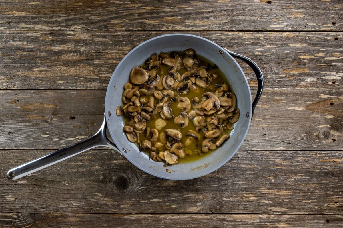 Cooked sliced mushrooms in butter in a skillet.