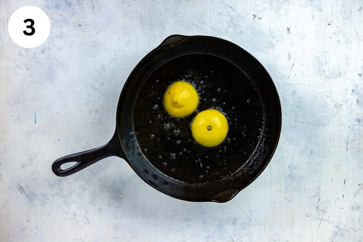 Two fresh lemon halves in a cast iron skillet.