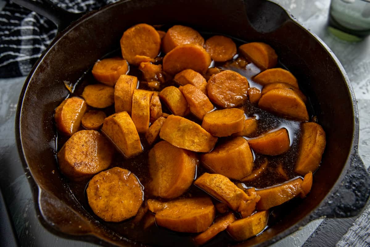 Cooked sliced sweet potatoes, butter, and seasonings in skillet.