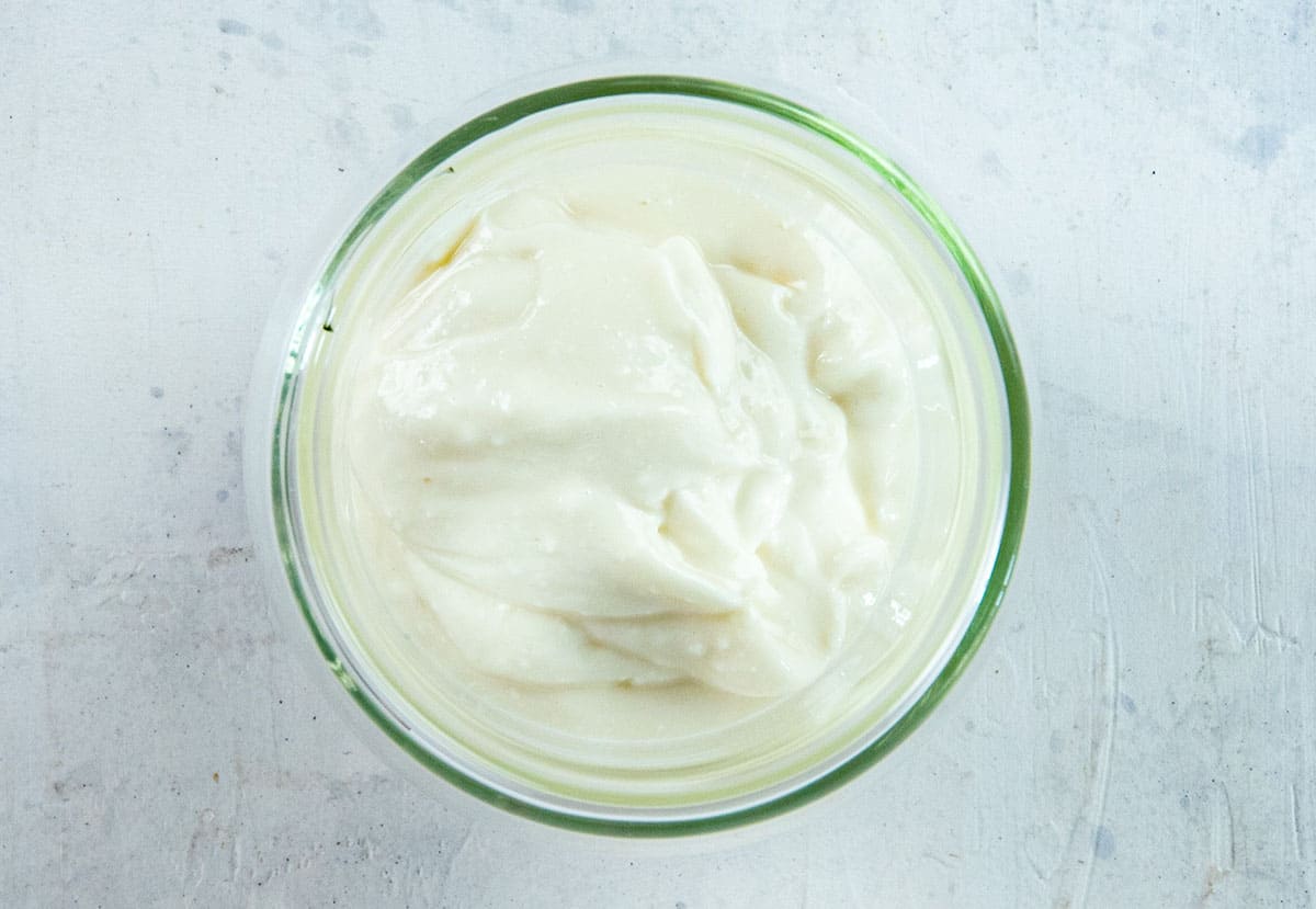 Cream cheese, yogurt, honey, and vanilla extract blended in glass bowl.