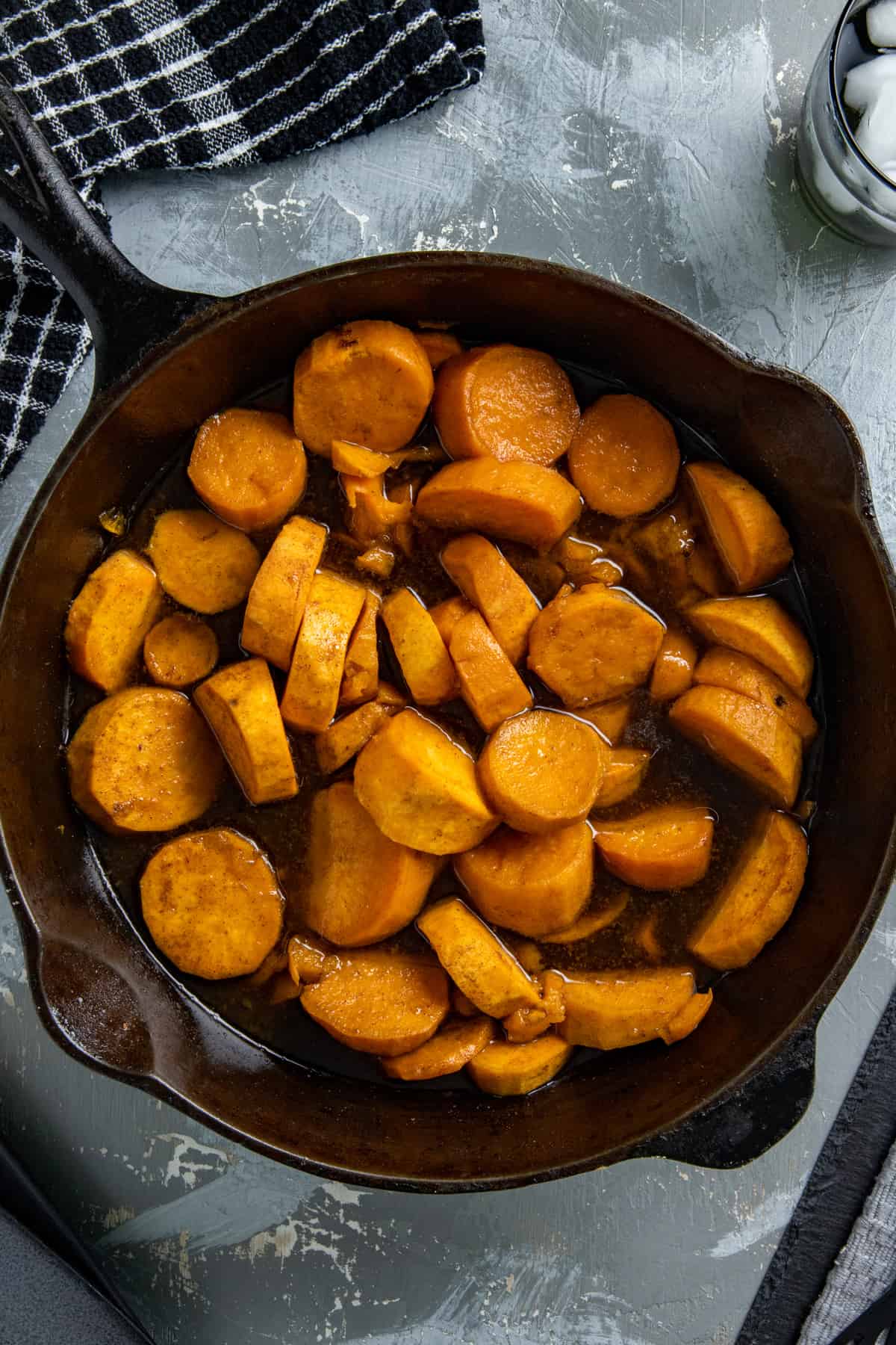 Cooked candied sweet potatoes in a cast iron skillet.