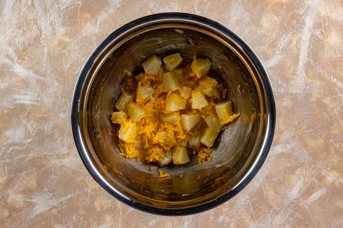 Cheese and pineapple chunks added to the bowl.