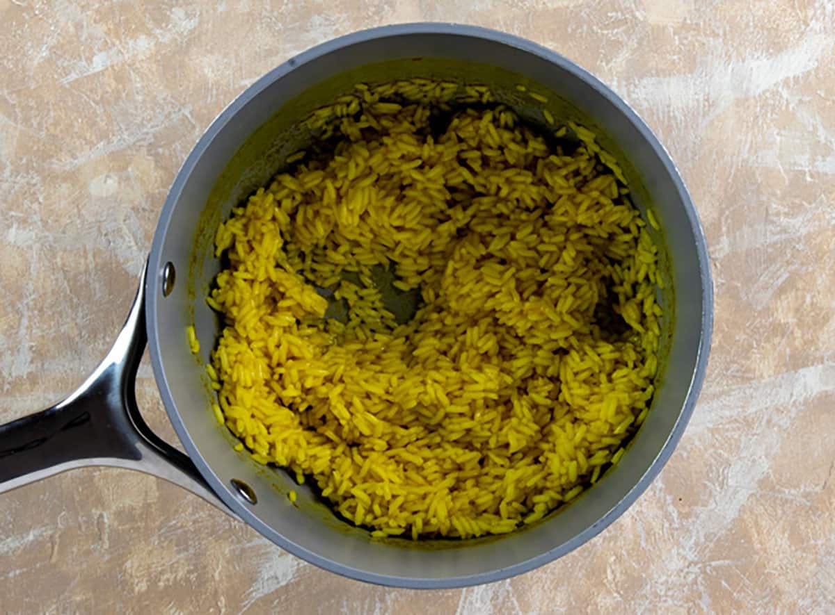 Cooked yellow rice in small pot.