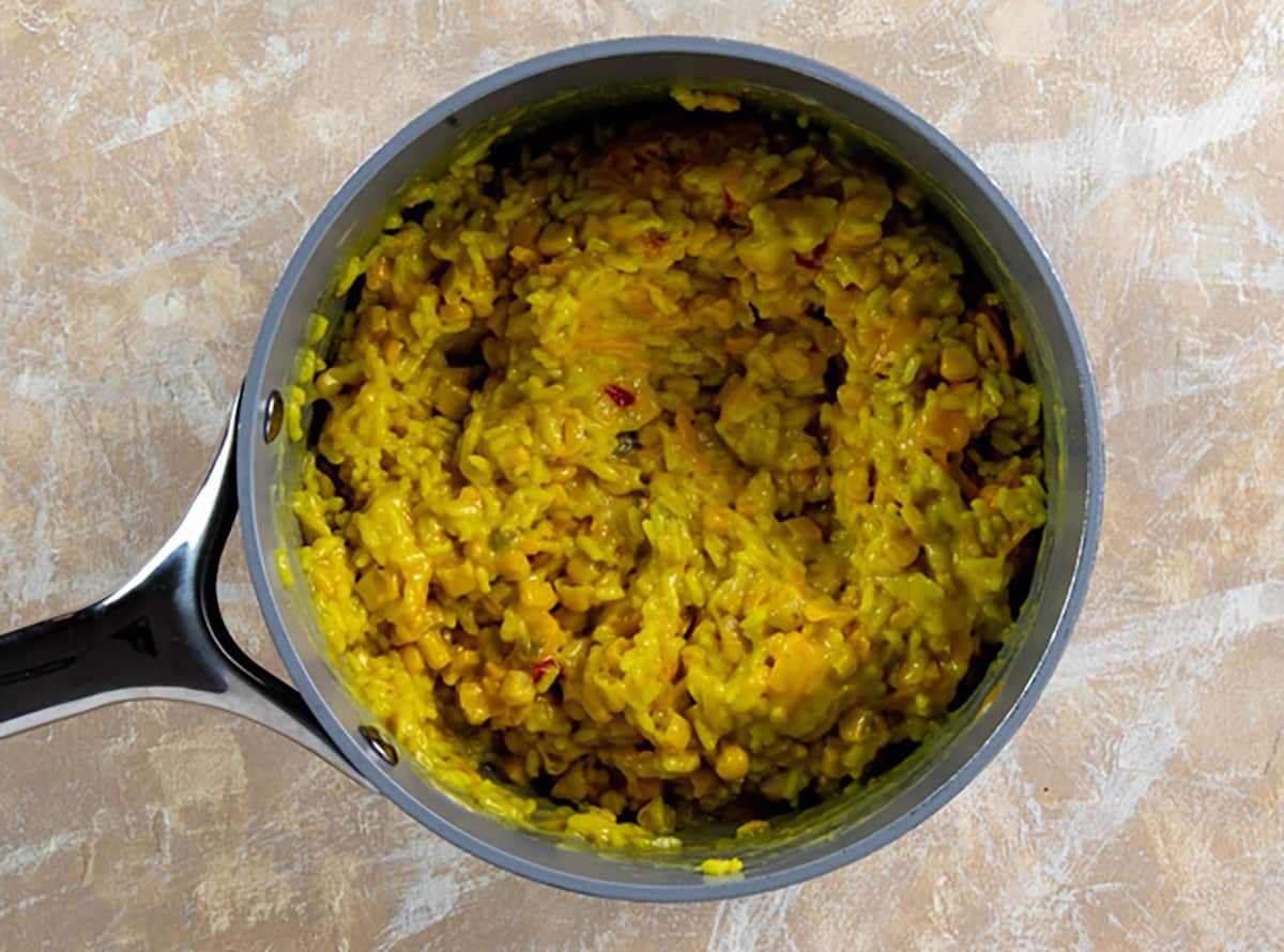 Corn, cream of chicken soup, and cheese added to rice in the pot.