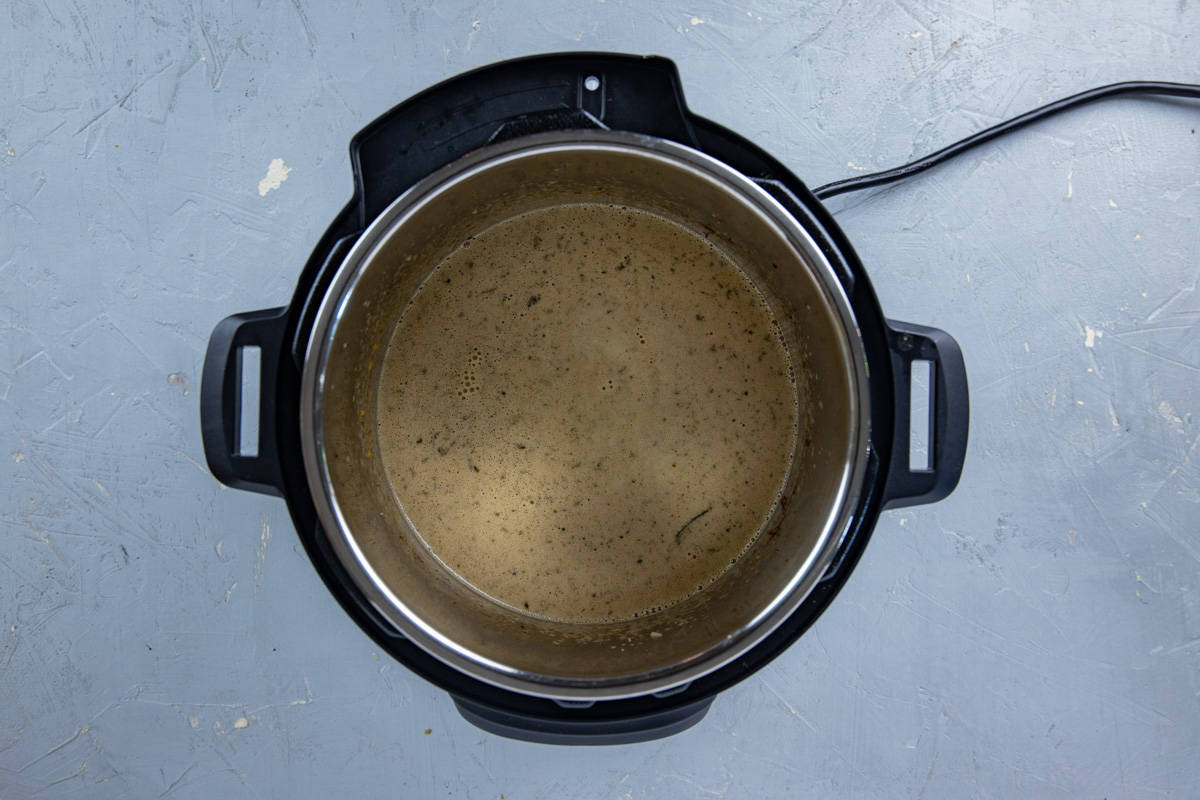 Broth mixture that has been blended with an immersion blender inside the pot.
