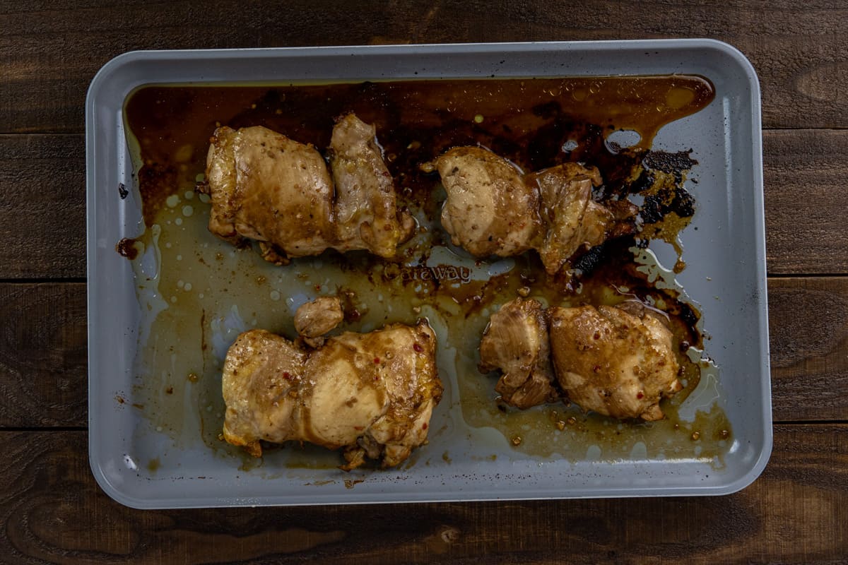Baked chicken thighs on a sheet pan.