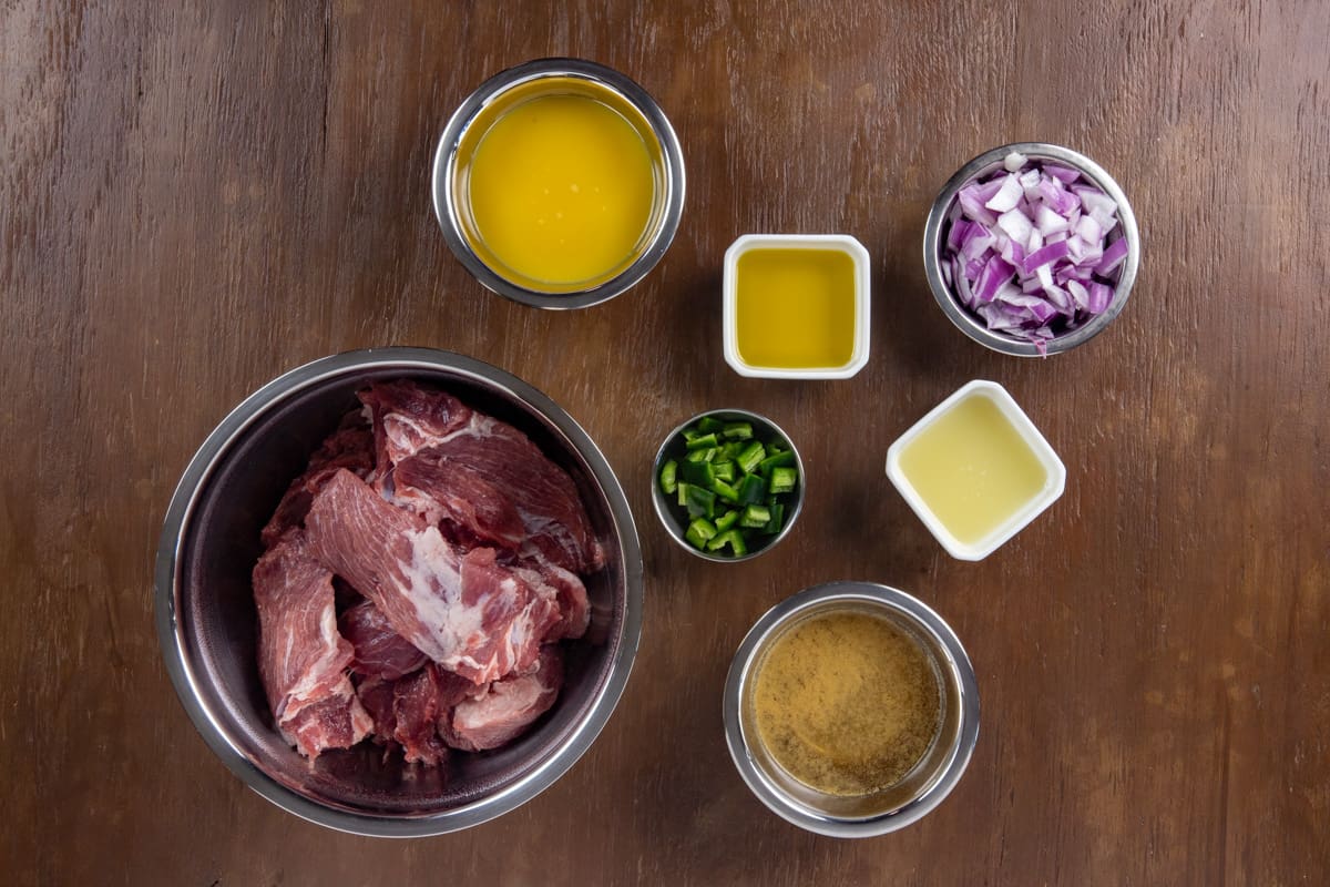 Pork carnitas ingredients measured out in individual containers.