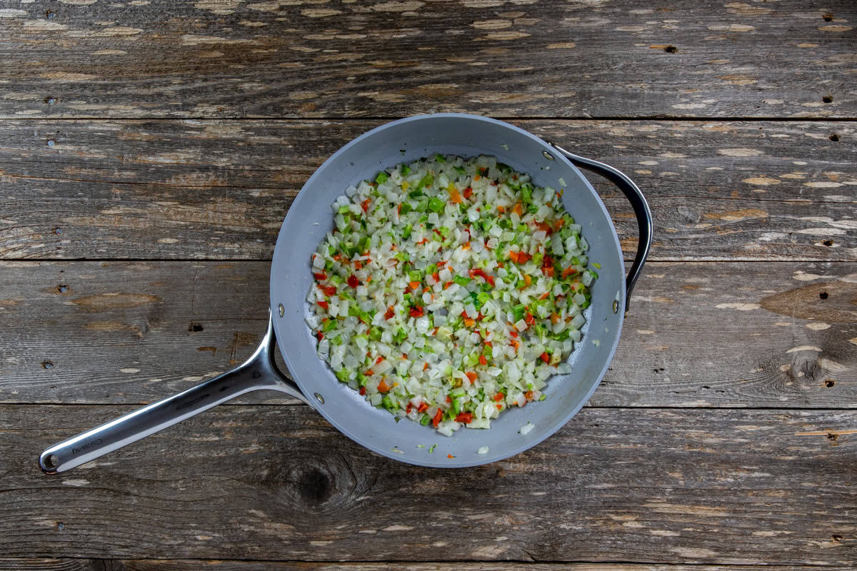 Sauteed chopped onion, bell pepper, and celery cooked in butter in a skillet.