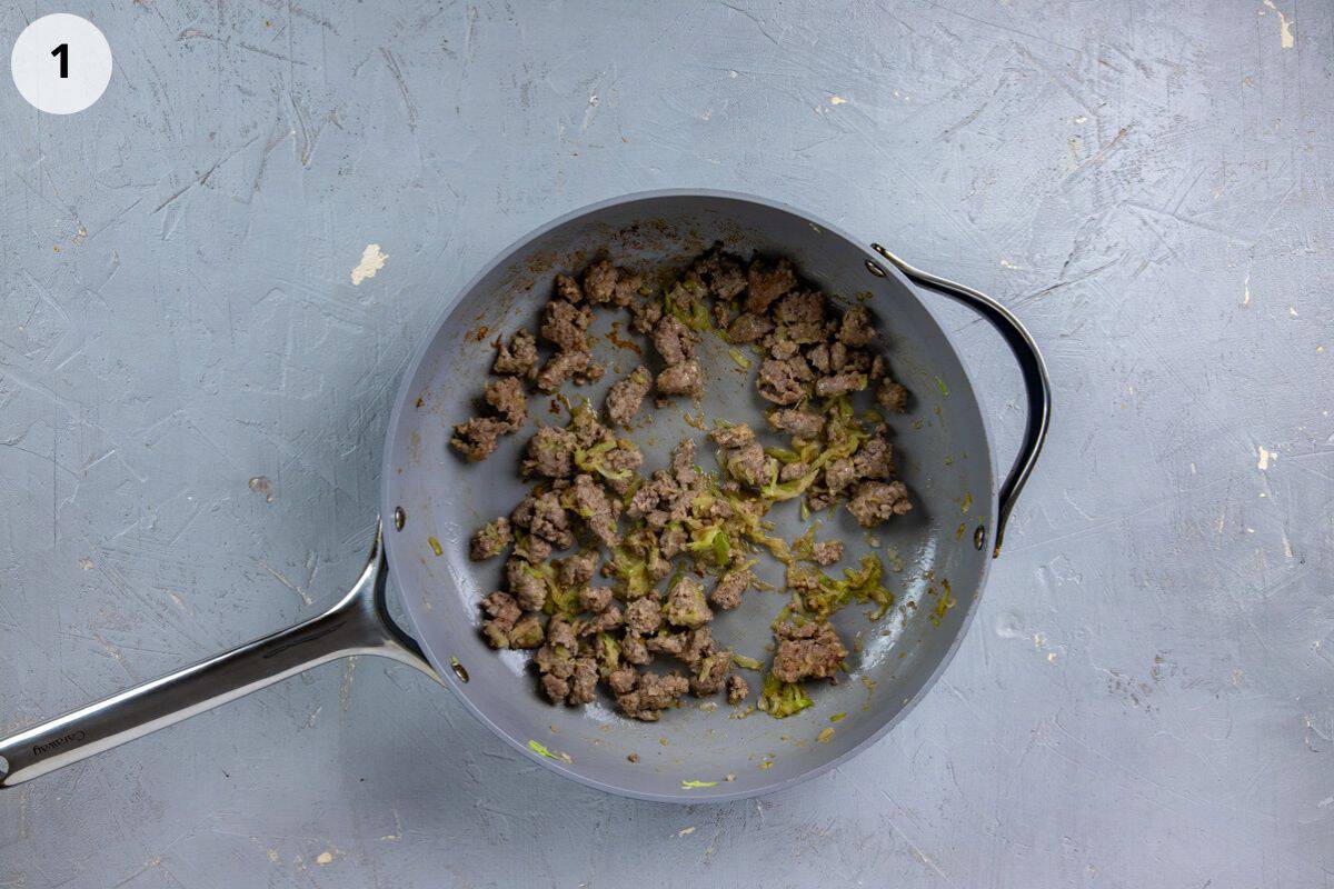 Sausage, onion, and celery cooked in a skillet.