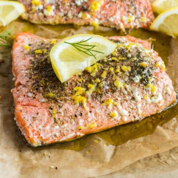 Baked salmon fillet topped with lemon zest and dill weed.