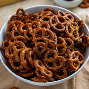 Seasoned pretzels and a white serving bowl.
