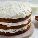 Three layer carrot cake with cream cheese frosting in between the layers and on top. Sides not frosted.