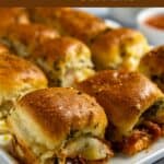 Close up of baked meatball sliders on a white serving platter.